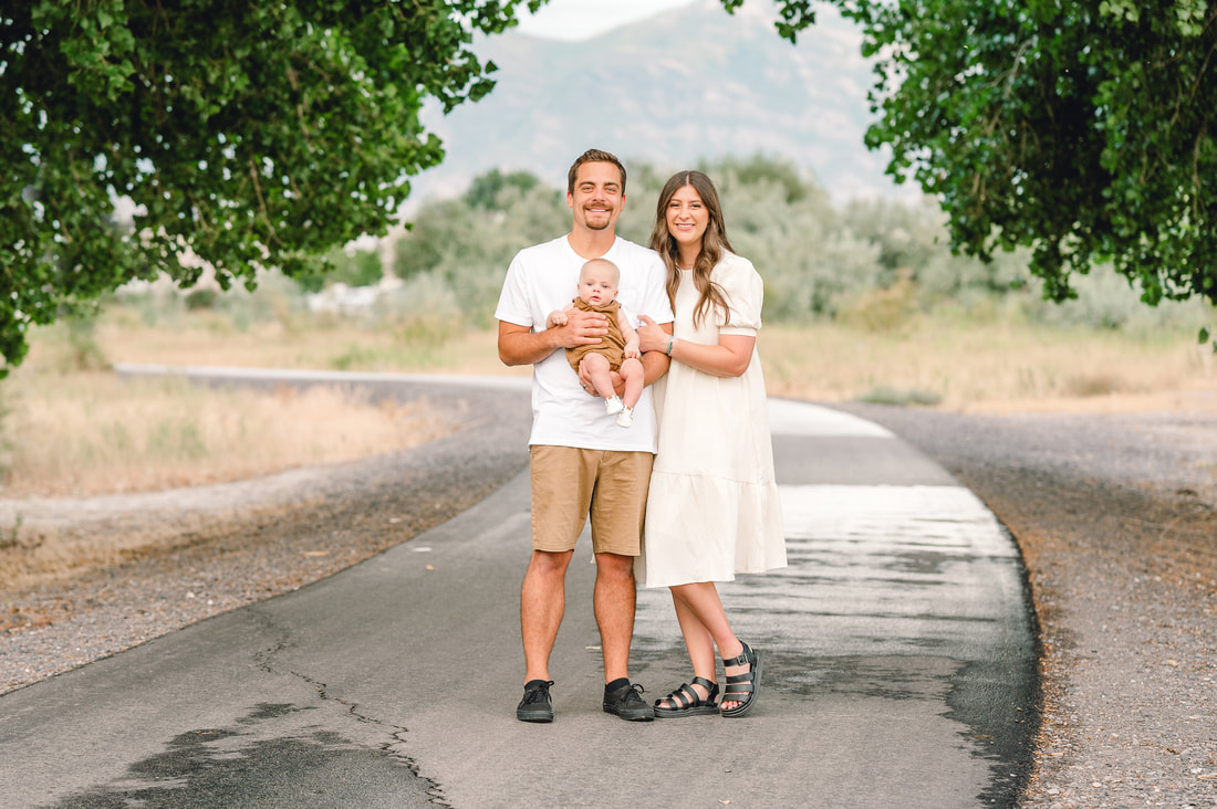 Couple in neutral clothing holding baby during fall family photos by Flying Gull Photography