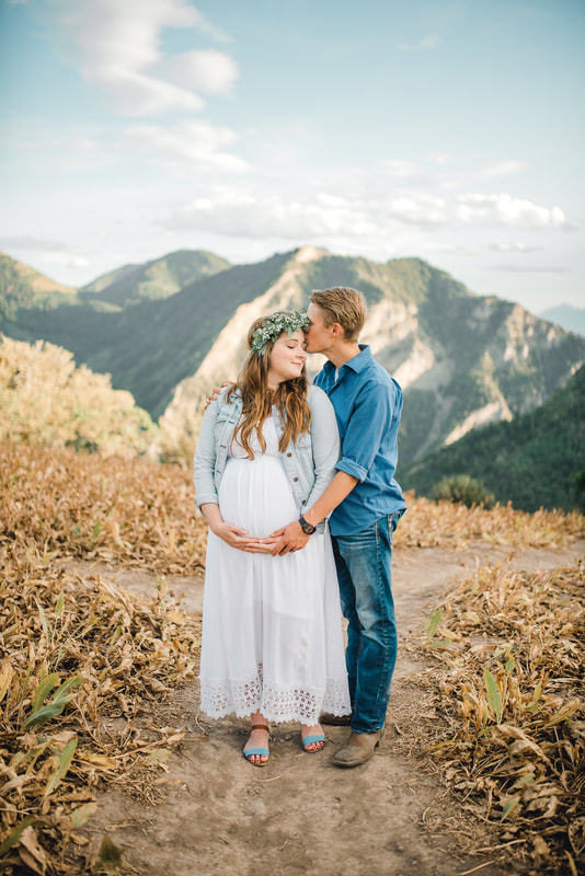 Husband kisses pregnant wife at Squaw Peak overlook in Provo Canyon