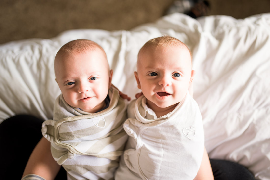 Newborn twin brothers in baby wraps