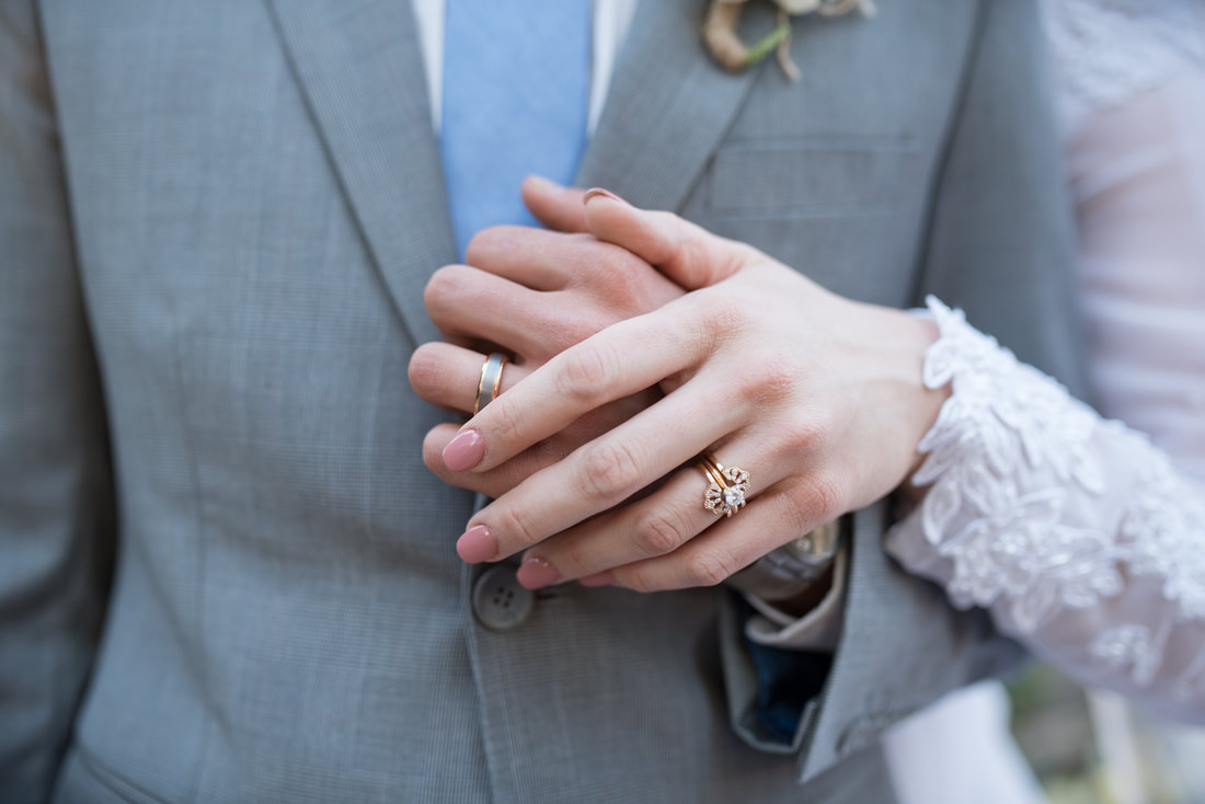 Close up of bride and groom hands and rings