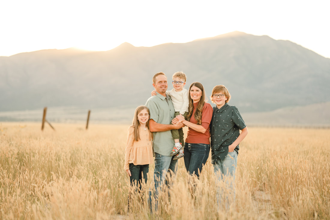 Family of 5 standing in a golden field by Utah family photographer, Flying Gull Photography