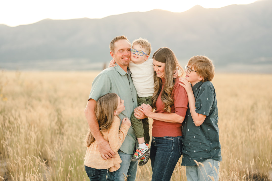Little boy snuggles family during fall mini photo session in Eagle Mountain Utah