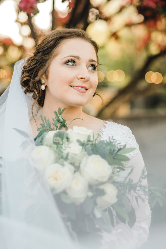 Bride smiles behind a veil