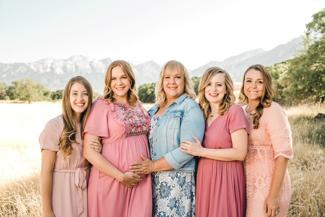 Family photo in a field with Utah mountains behind