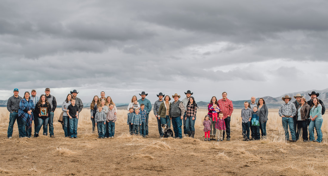 Large family photo in a field with moody clouds and lighting