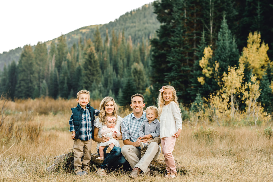 Family photo at Jordan Pines in Big Cottonwood Canyon with Utah mountains behind