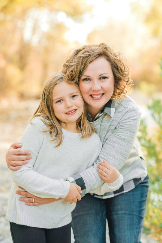 Portrait of mother holding daughter at a park with fall colors