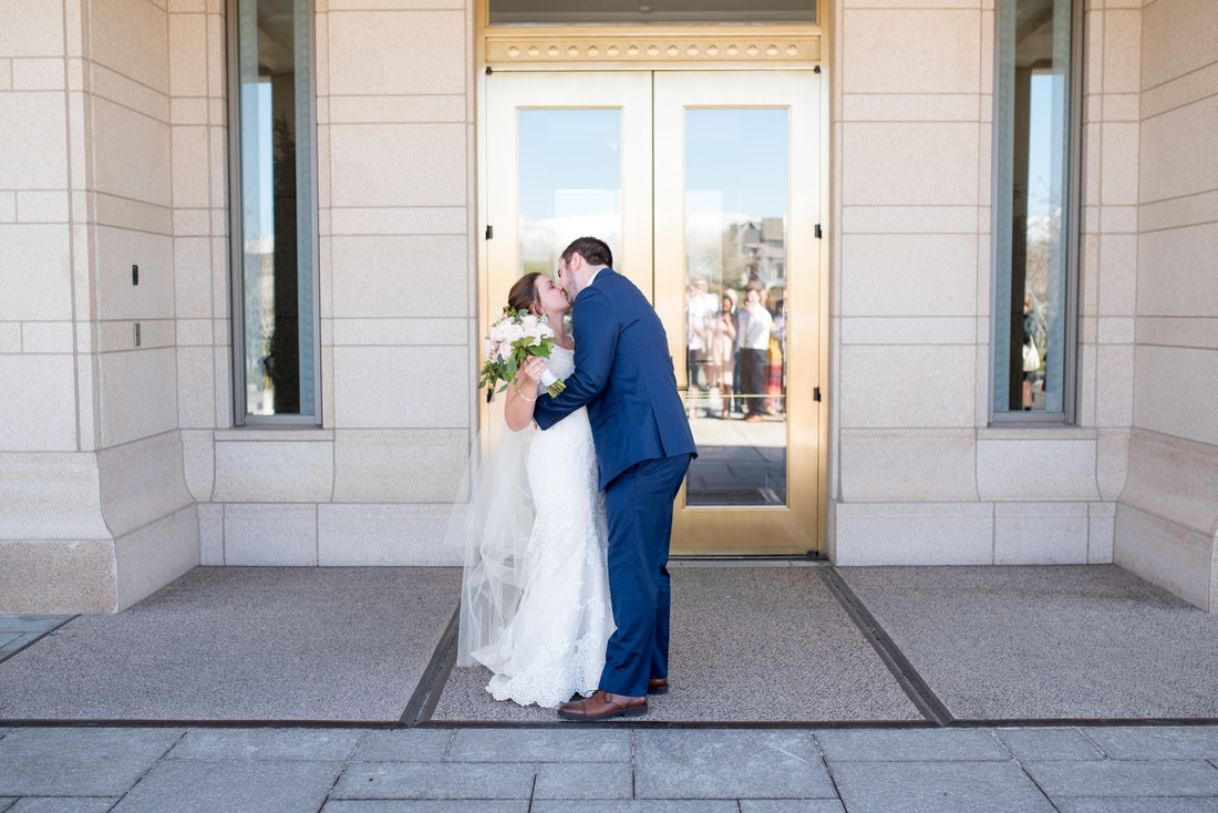 Bride and Groom exiting and kissing in front of LDS Temple