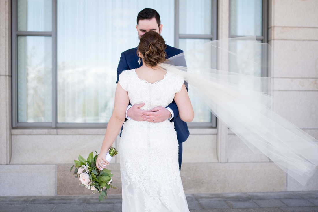 Bride in lace dress and groom in navy suit