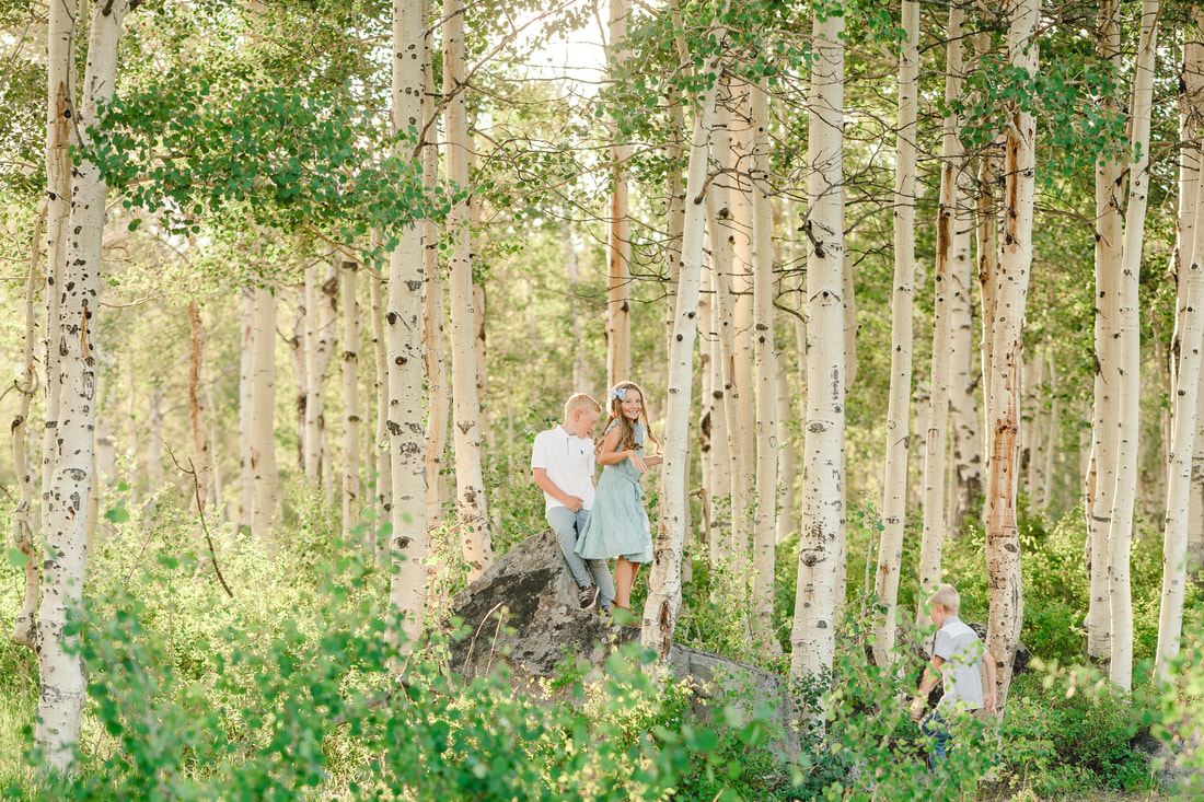 Kids scamper around on a boulder during family photos