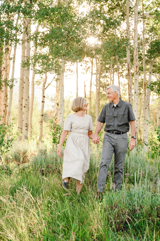 Older couple smiling at each other in Utah wildflower meadow