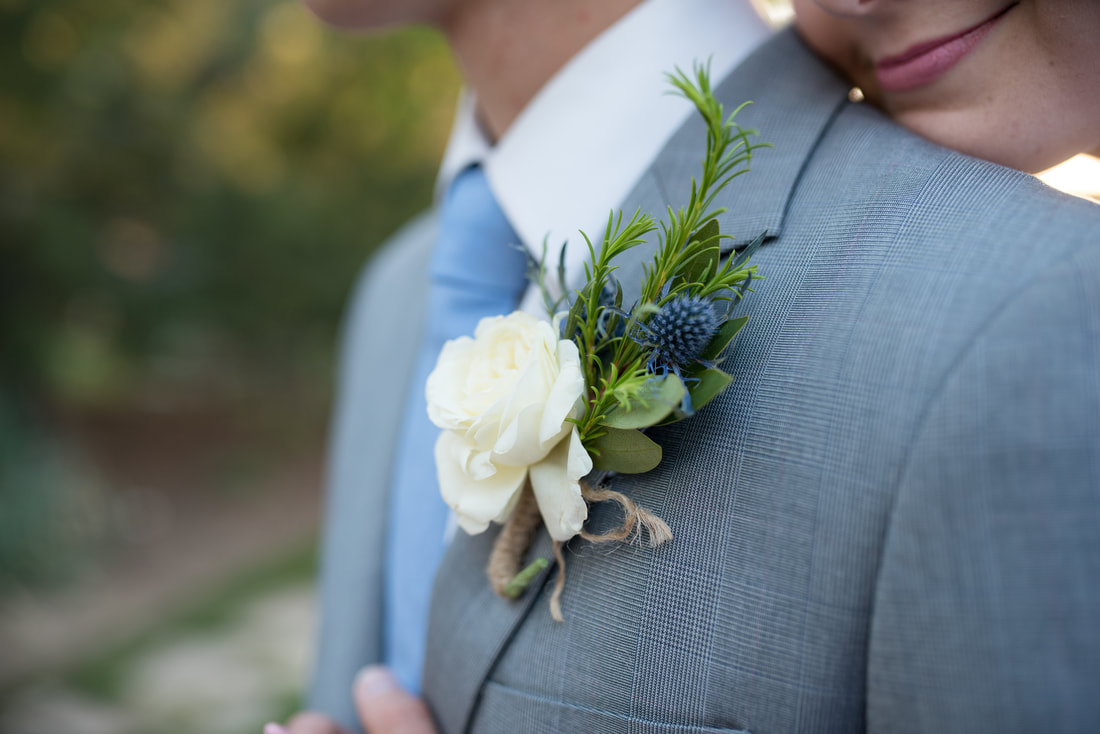 Groom close up boutonniere with thistle and white rose 