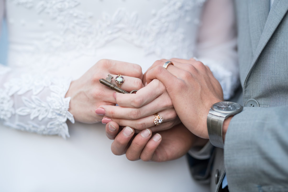 Bride and groom's hands with rings and special gift