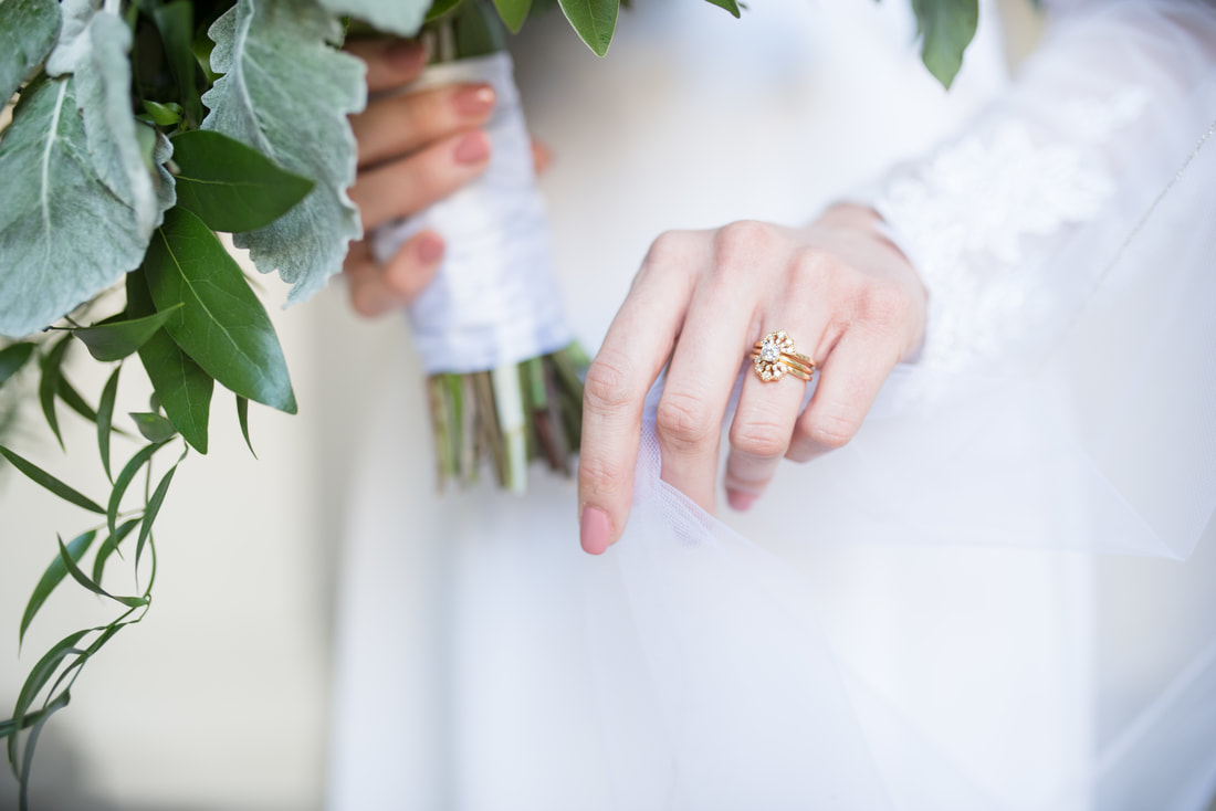 Close-up of bride's hand with veil and antique yellow gold wedding ring