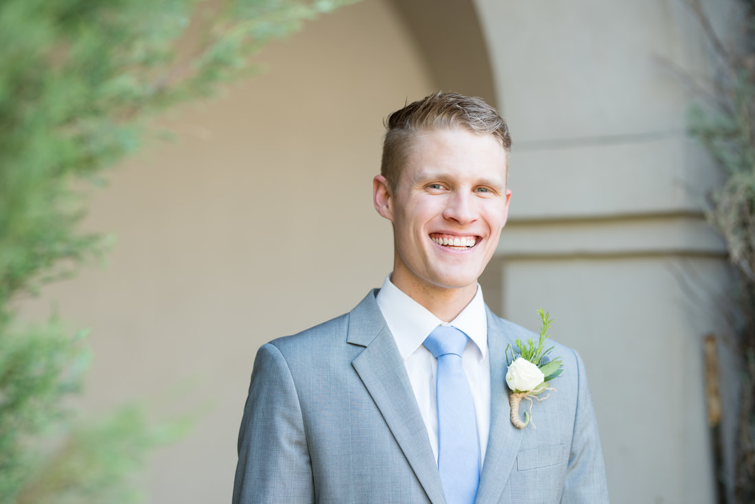 Smiling groom in gray suit at Thanksgiving Point gardens