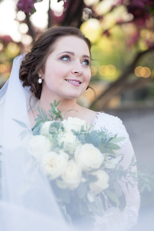 Close-up portrait of bride with flowers in background