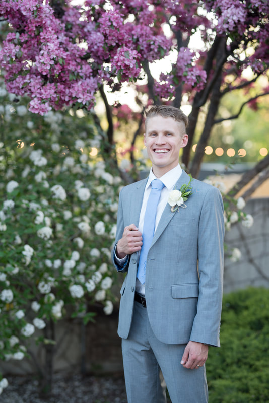 Groom portrait with flowers in background